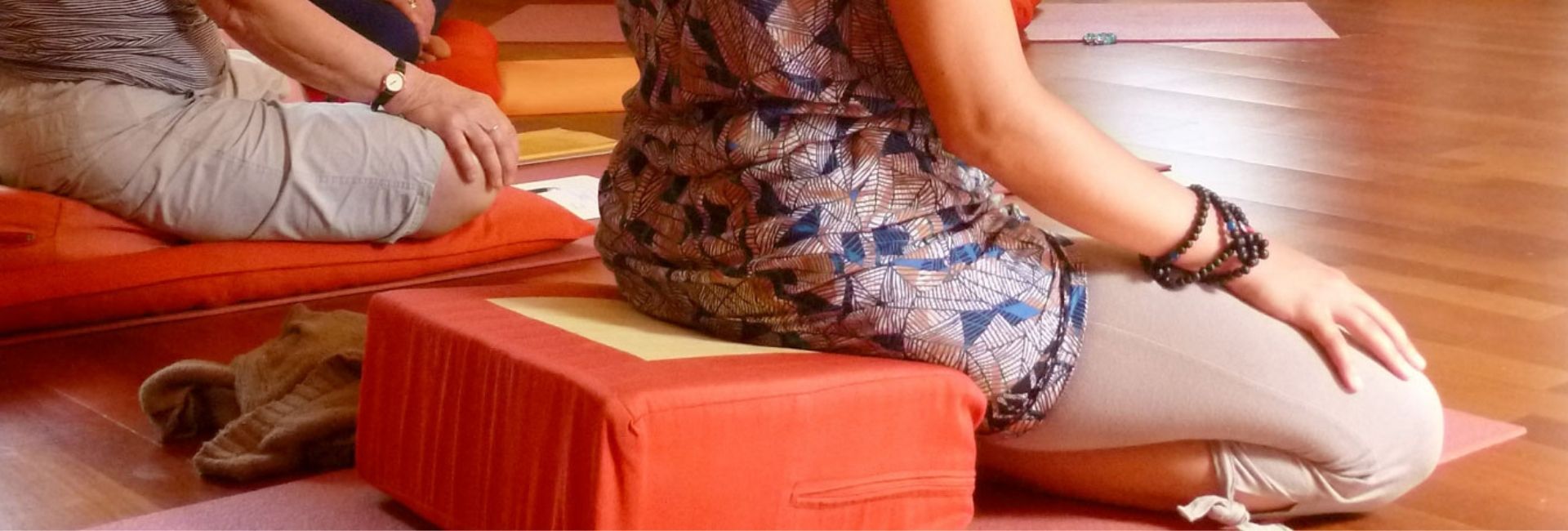 Pratiquantes en méditation assise sur coussins rouges lors d'un week-end de pleine présence à Nigu Karma Ling