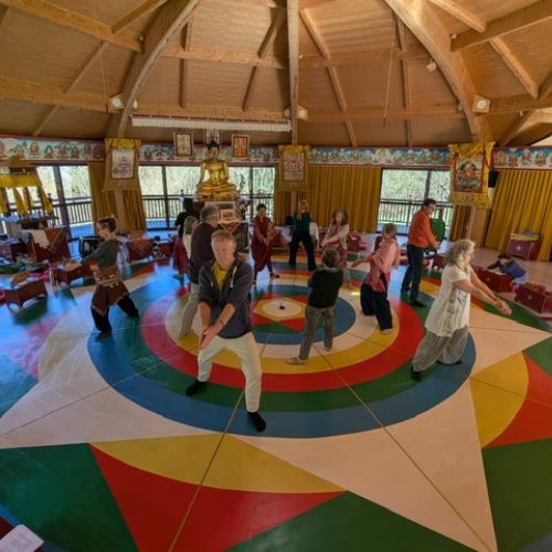 Danse du Vajra – Groupe en pratique – Nigu Karma Ling Groupe de pratiquants dansant sur le mandala coloré de la Danse du Vajra dans le temple de Nigu Karma Ling