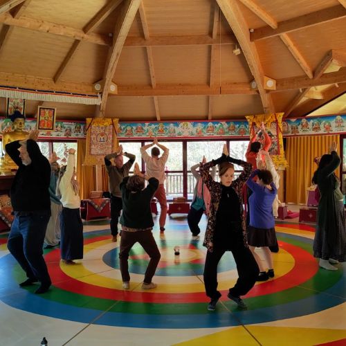 Danse du Vajra – Pratique Dzogchen – Nigu Karma Ling Pratiquants bras levés sur le mandala coloré de la Danse du Vajra dans le temple de Nigu Karma Ling