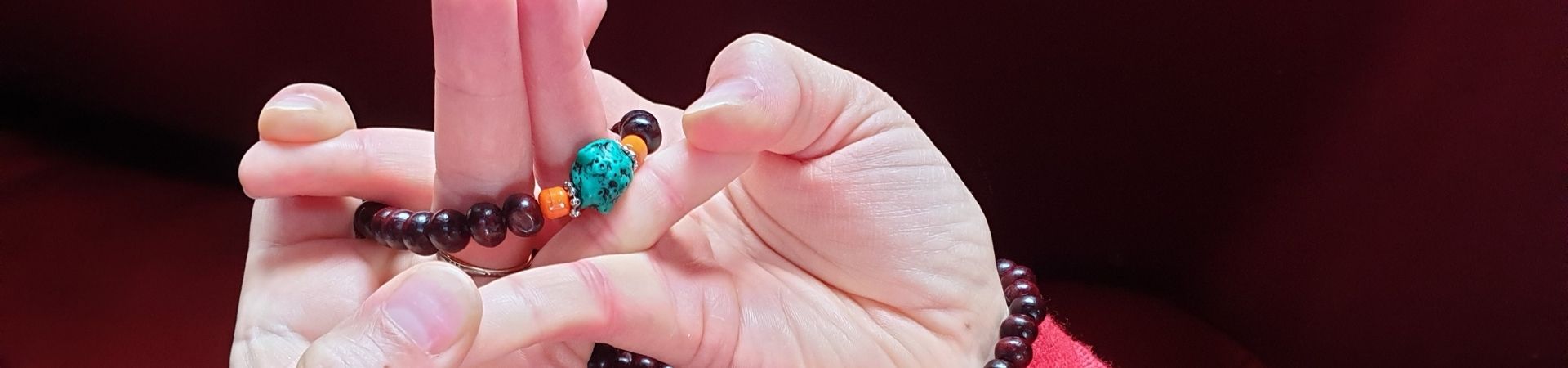Mains en mudrā tenant un mala lors d'une pratique de méditation — Mandala des cinq énergies élémentaires, Karma Ling, Savoie