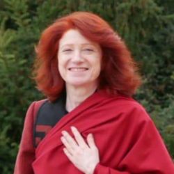 Portrait de Lama Dominique Zangmo, enseignante de yoga intérieur, la main posée sur le cœur