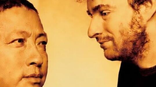 Lama Gyurmé et Jean-Philippe Rykiel, duo de chants sacrés tibétains, se regardant sur fond doré